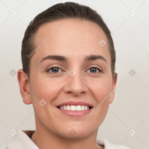 Joyful white young-adult female with short  brown hair and grey eyes