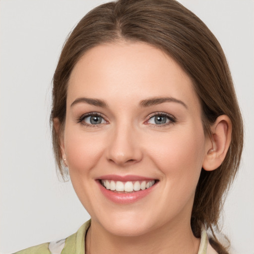 Joyful white young-adult female with medium  brown hair and grey eyes