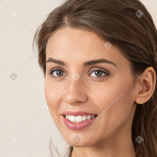 Joyful white young-adult female with long  brown hair and brown eyes