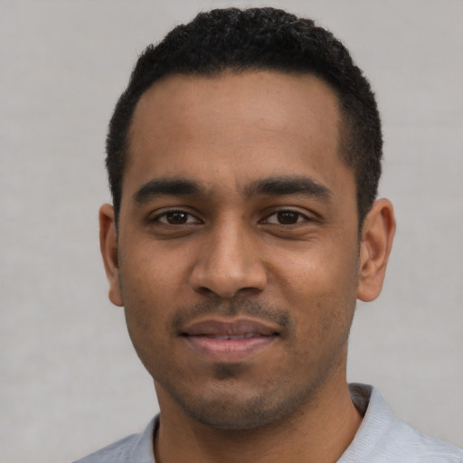 Joyful black young-adult male with short  black hair and brown eyes