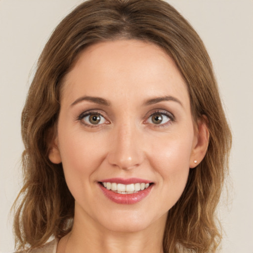 Joyful white young-adult female with long  brown hair and green eyes