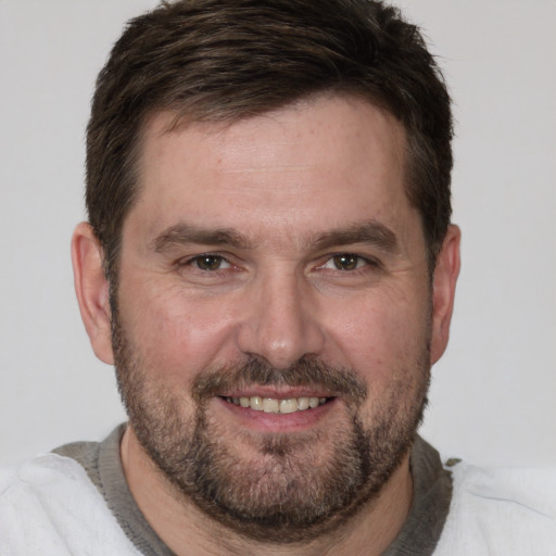 Joyful white adult male with short  brown hair and brown eyes