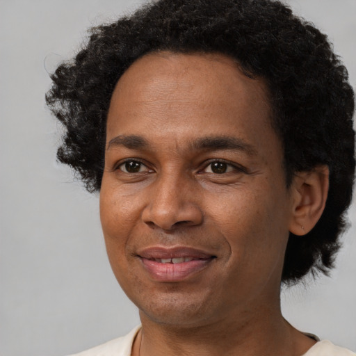 Joyful black adult male with short  black hair and brown eyes
