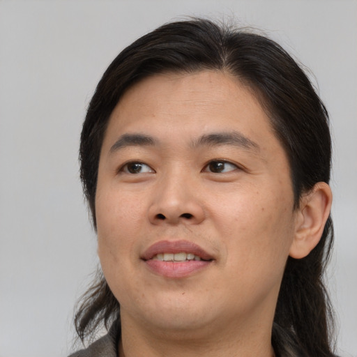 Joyful asian adult male with medium  brown hair and brown eyes