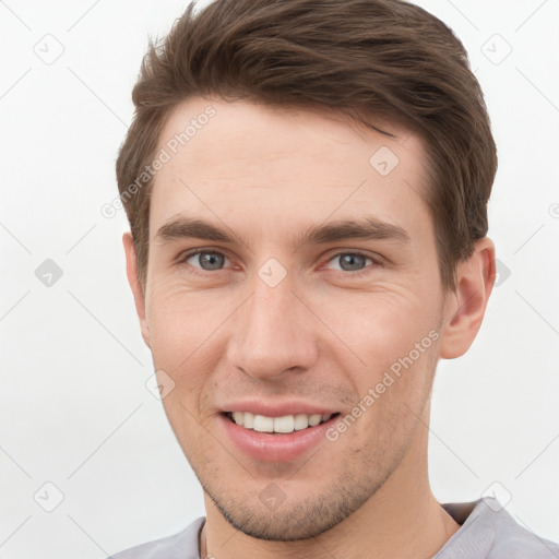 Joyful white young-adult male with short  brown hair and grey eyes