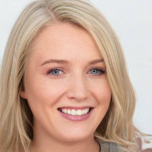 Joyful white young-adult female with long  blond hair and blue eyes