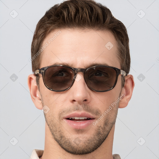 Joyful white young-adult male with short  brown hair and grey eyes