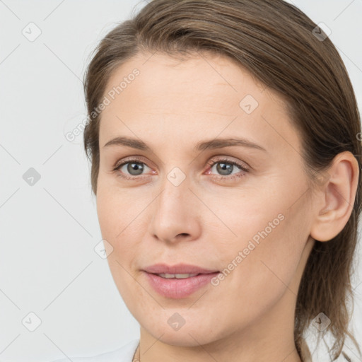 Joyful white young-adult female with medium  brown hair and grey eyes