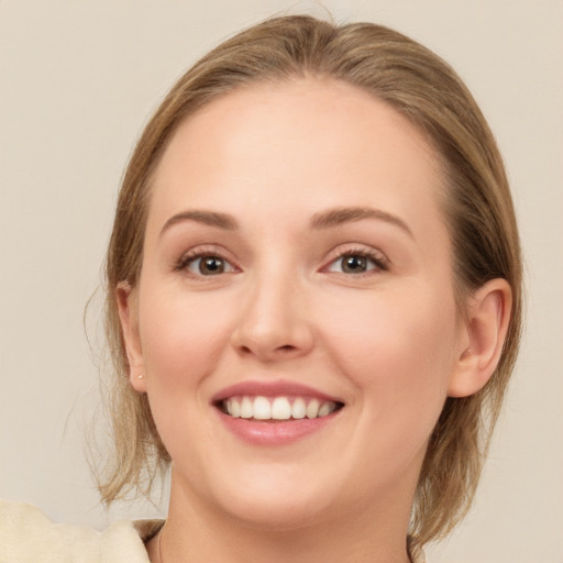 Joyful white young-adult female with medium  brown hair and grey eyes