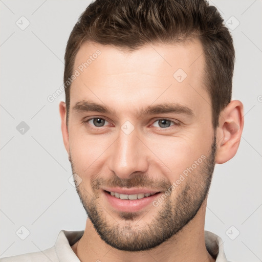 Joyful white young-adult male with short  brown hair and brown eyes