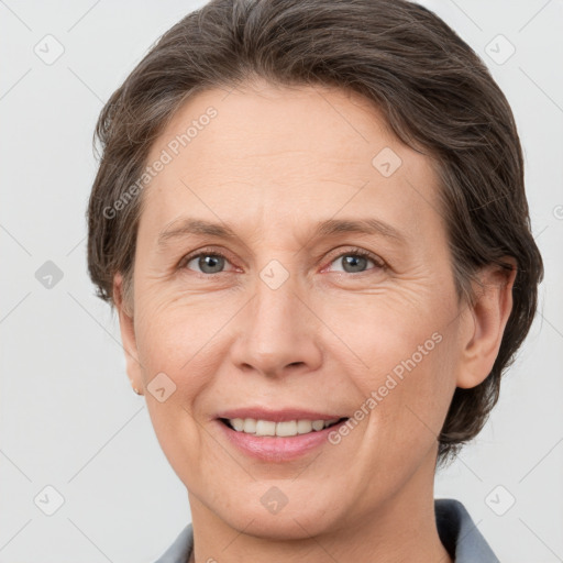 Joyful white adult female with medium  brown hair and grey eyes