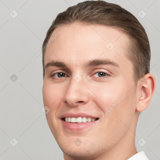 Joyful white young-adult male with short  brown hair and grey eyes