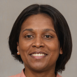 Joyful black adult female with medium  brown hair and brown eyes