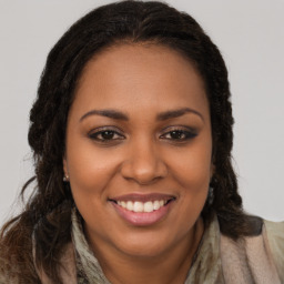 Joyful black young-adult female with long  brown hair and brown eyes