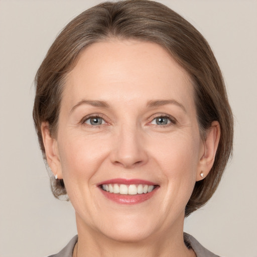 Joyful white adult female with medium  brown hair and grey eyes