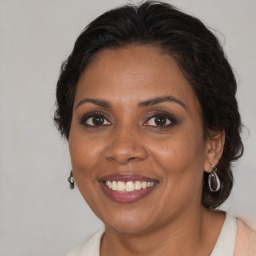 Joyful black adult female with medium  brown hair and brown eyes