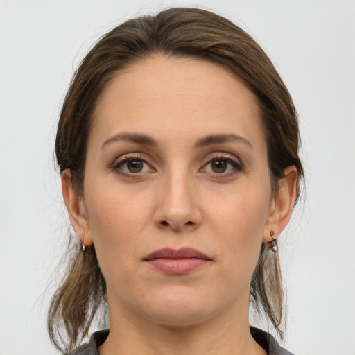 Joyful white young-adult female with medium  brown hair and grey eyes