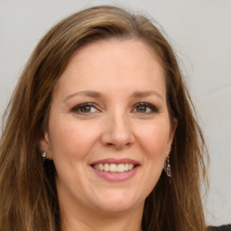 Joyful white adult female with long  brown hair and grey eyes