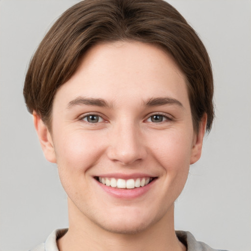 Joyful white young-adult female with short  brown hair and grey eyes