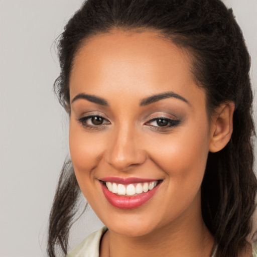 Joyful latino young-adult female with long  brown hair and brown eyes