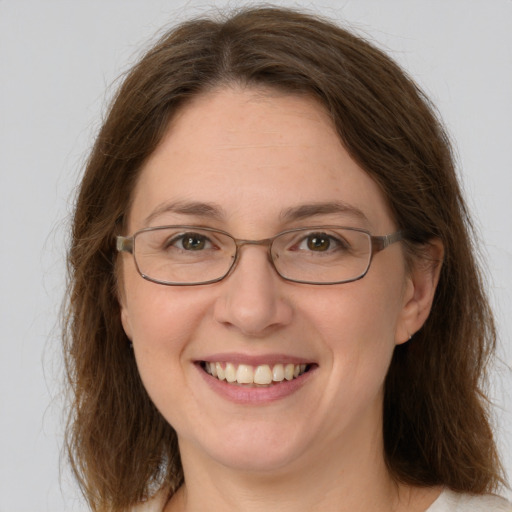 Joyful white adult female with medium  brown hair and green eyes