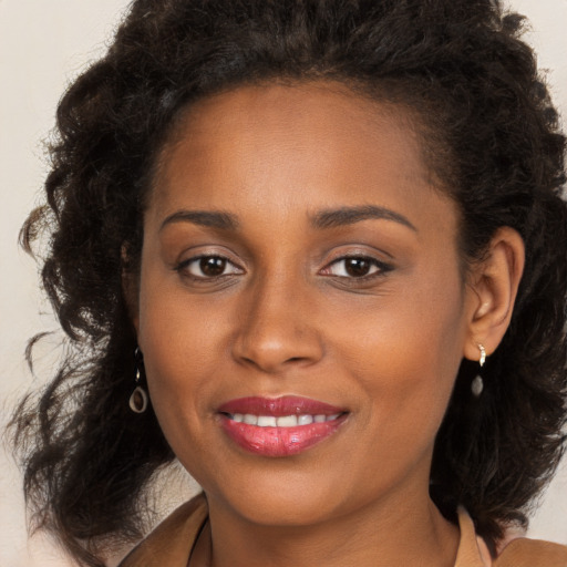 Joyful black young-adult female with long  brown hair and brown eyes