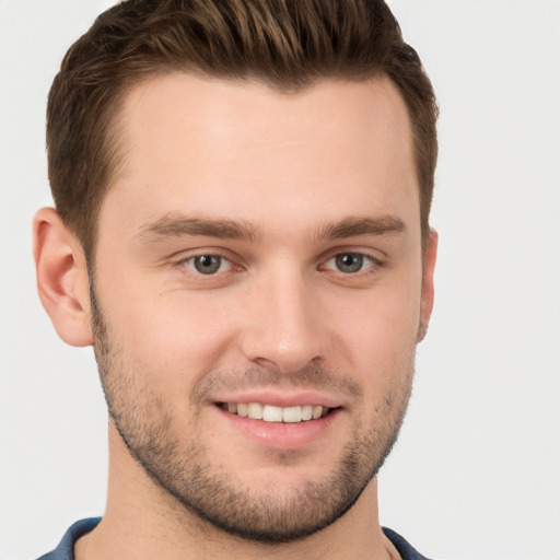 Joyful white young-adult male with short  brown hair and grey eyes