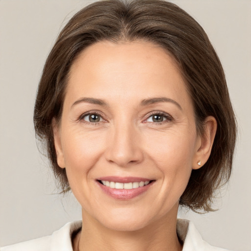 Joyful white adult female with medium  brown hair and brown eyes