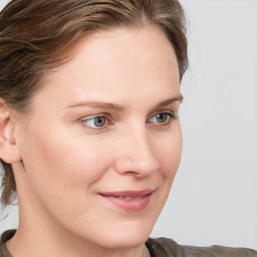 Joyful white young-adult female with medium  brown hair and blue eyes