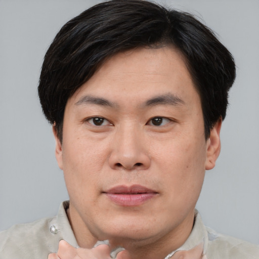 Joyful asian young-adult male with short  brown hair and brown eyes