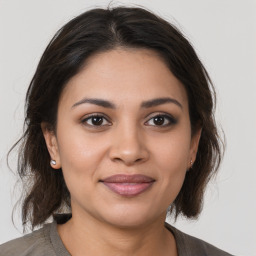 Joyful latino young-adult female with medium  brown hair and brown eyes