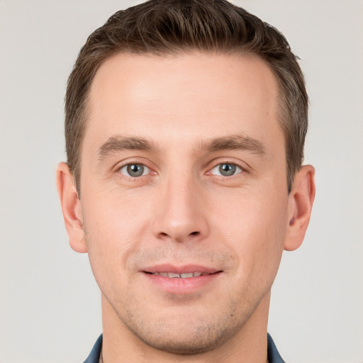 Joyful white young-adult male with short  brown hair and grey eyes