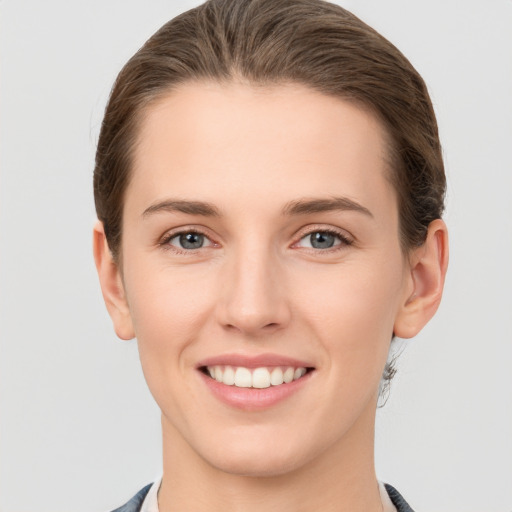 Joyful white young-adult female with short  brown hair and grey eyes