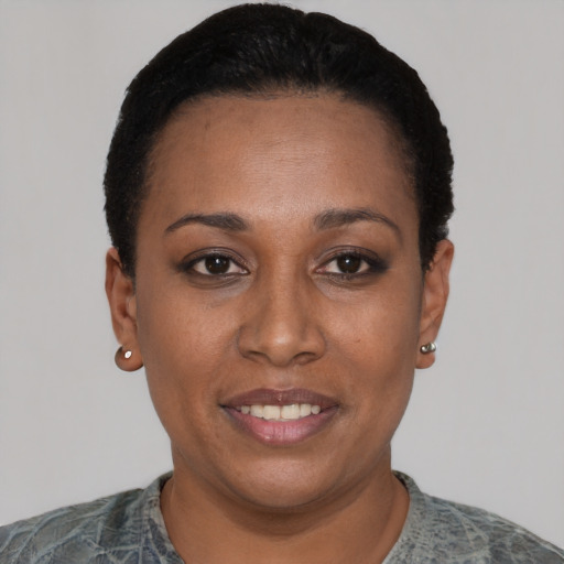 Joyful black young-adult female with short  black hair and brown eyes