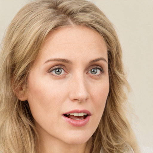 Joyful white young-adult female with long  brown hair and blue eyes