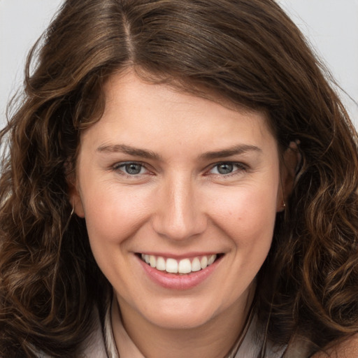 Joyful white young-adult female with long  brown hair and brown eyes