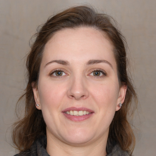 Joyful white adult female with medium  brown hair and grey eyes