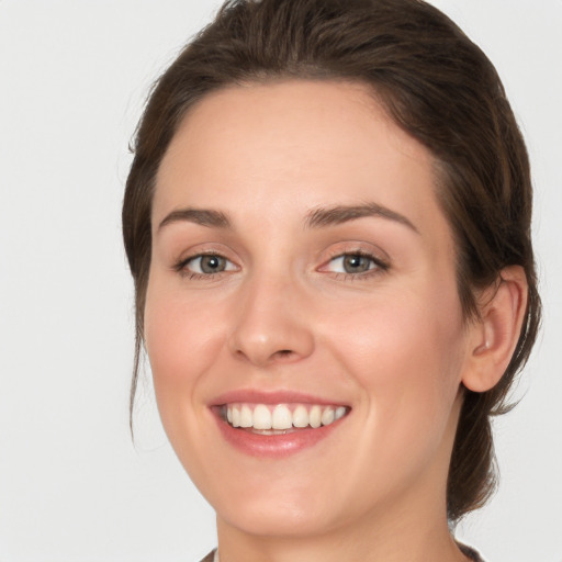 Joyful white young-adult female with medium  brown hair and green eyes