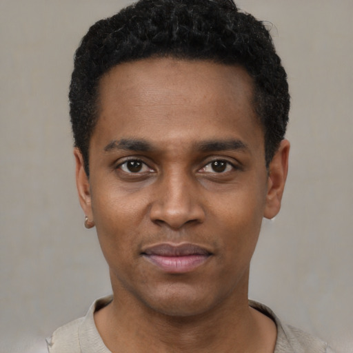 Joyful black young-adult male with short  black hair and brown eyes