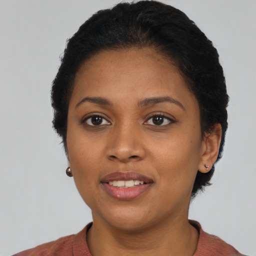 Joyful black young-adult female with short  black hair and brown eyes