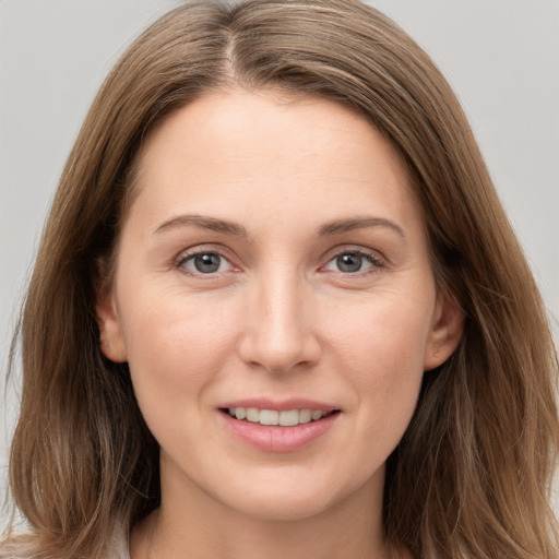 Joyful white young-adult female with long  brown hair and grey eyes