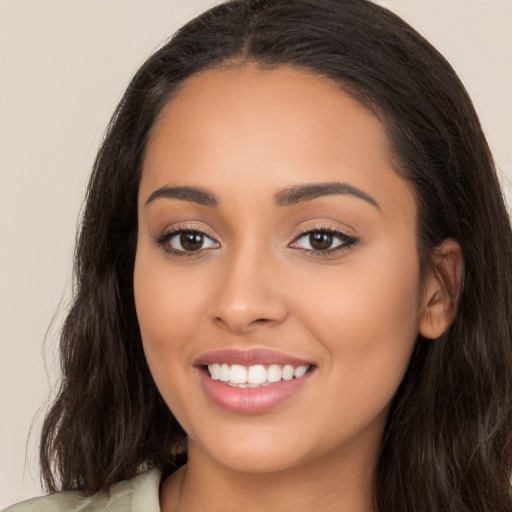 Joyful latino young-adult female with long  brown hair and brown eyes