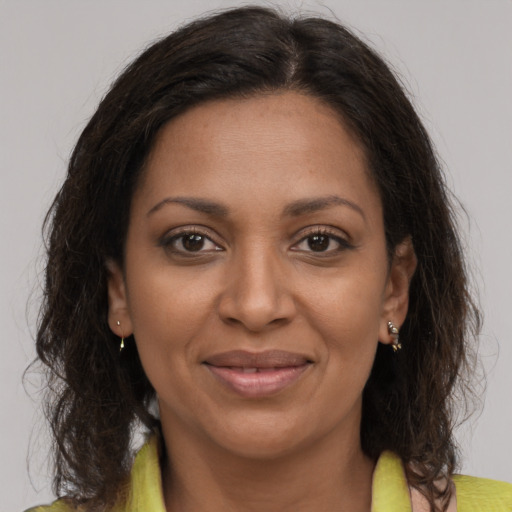 Joyful black adult female with medium  brown hair and brown eyes