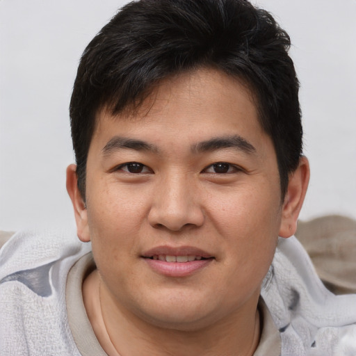 Joyful asian young-adult male with short  brown hair and brown eyes
