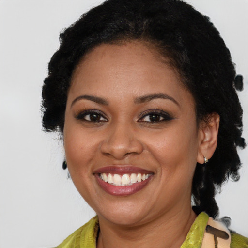 Joyful black young-adult female with long  brown hair and brown eyes