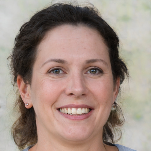 Joyful white adult female with medium  brown hair and green eyes