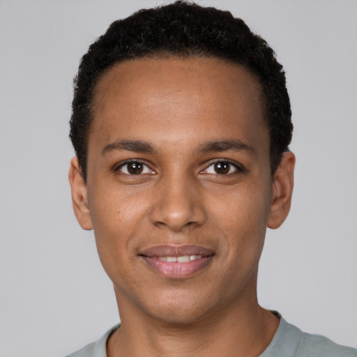 Joyful black young-adult male with short  black hair and brown eyes