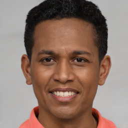 Joyful latino young-adult male with short  brown hair and brown eyes