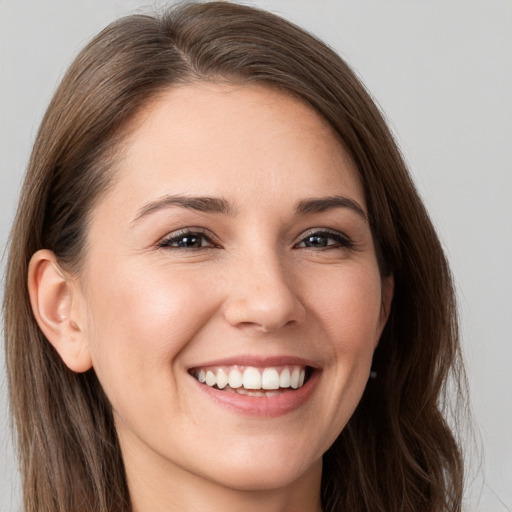 Joyful white young-adult female with long  brown hair and brown eyes