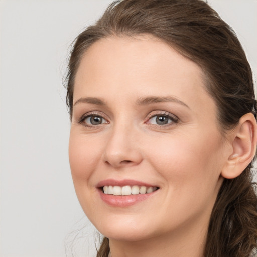 Joyful white young-adult female with long  brown hair and grey eyes